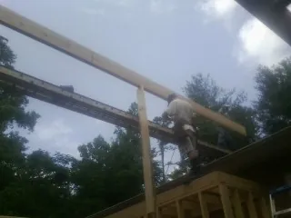 Carpenter setting a ridge beam over a new addition frame — Ice Dam Removal by Roofing Brothers in Sullivans Island