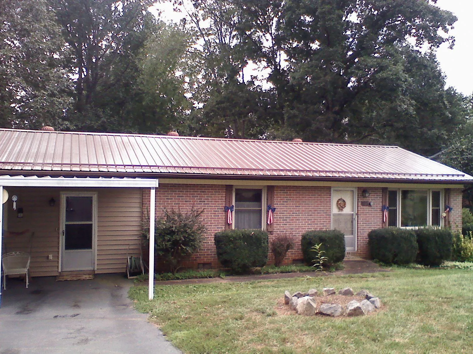 Bronze metal roof and carport on a brick ranch home — Roof Repair work by our crew in Sullivans Island